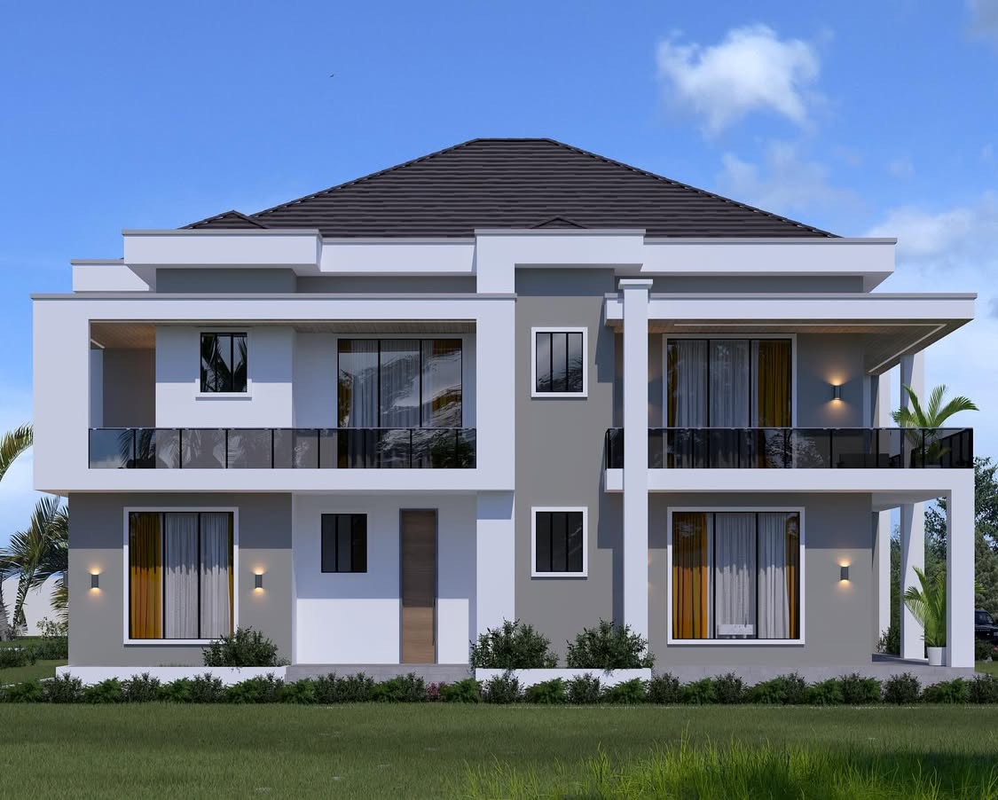 Symmetrical grey and white two-storey house with glass balustrade balconies, framed windows and wall lights above a green lawn